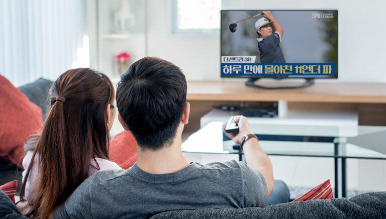 couple watching professional golf on tv with Korean titles