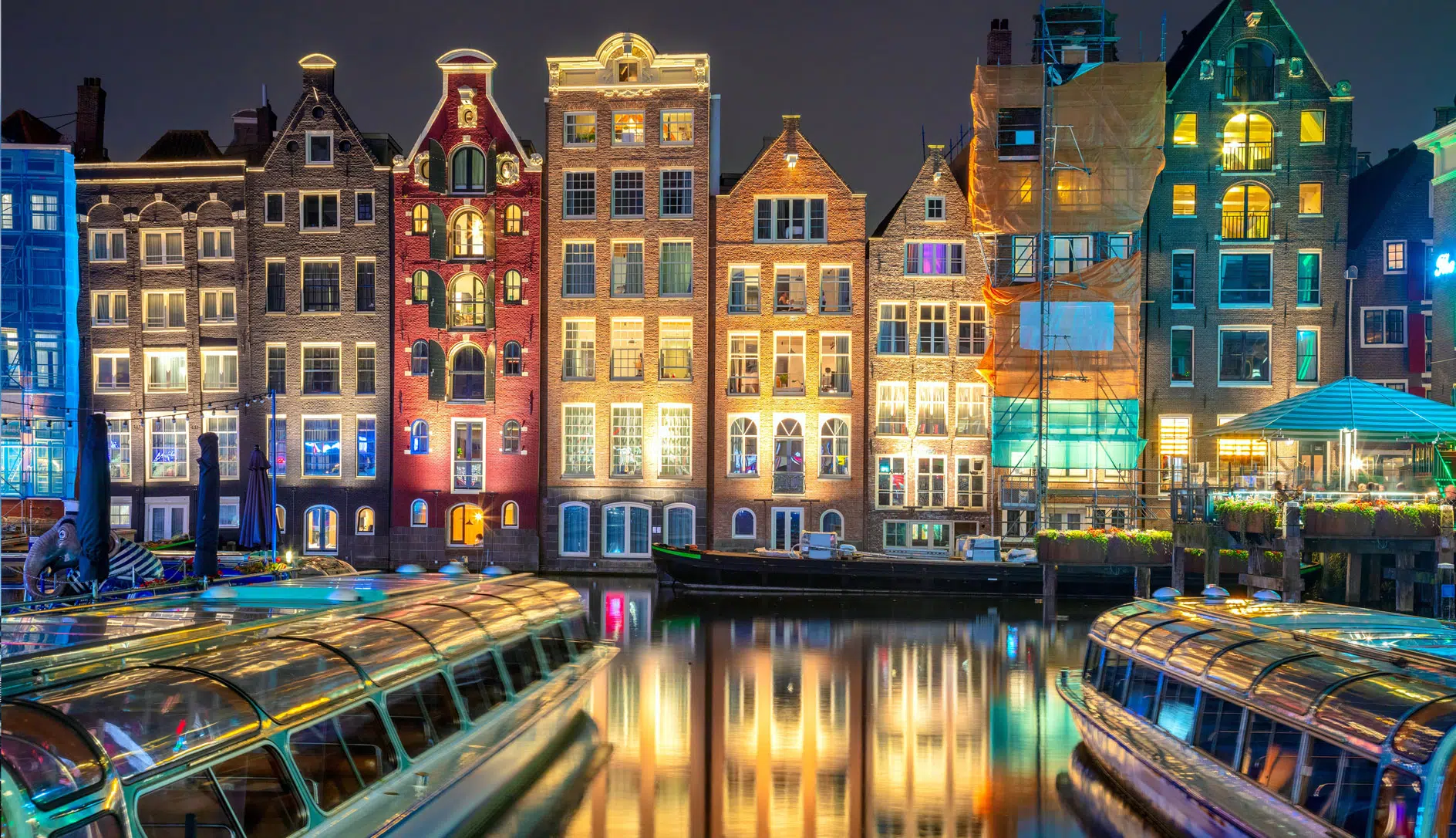 night time photo of row houses along the canal in Amsterdam