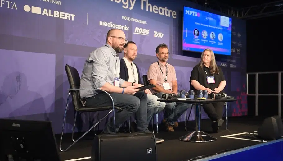 a group of panelists sitting on stage giving a talk