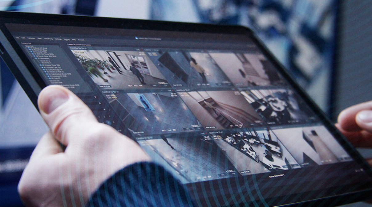 hands holding a tablet showing multiple video streams