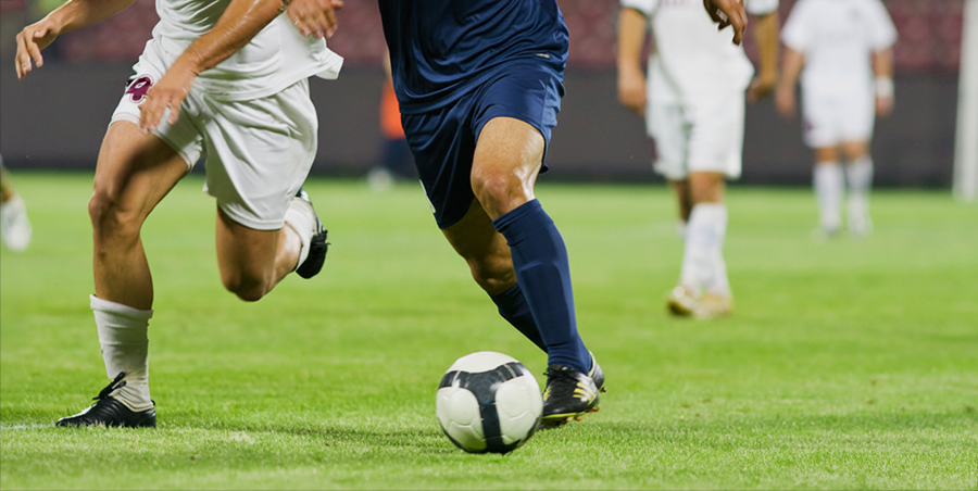 Soccer players running after the ball
